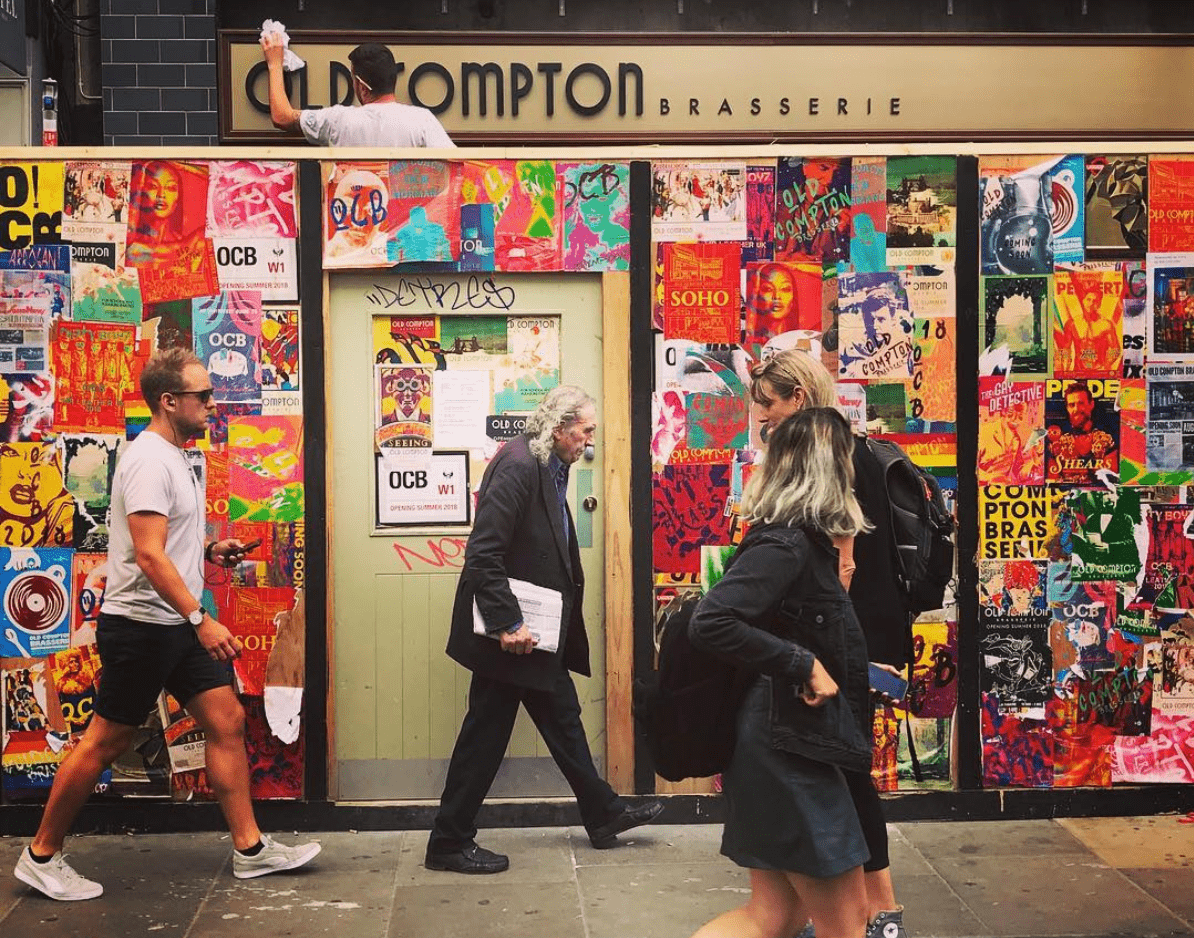 Old Compton Brasserie - Hoarding design and facade design showing the logo on the venue front, as well as the colourful posters surrounding the wooden construction hoarding.